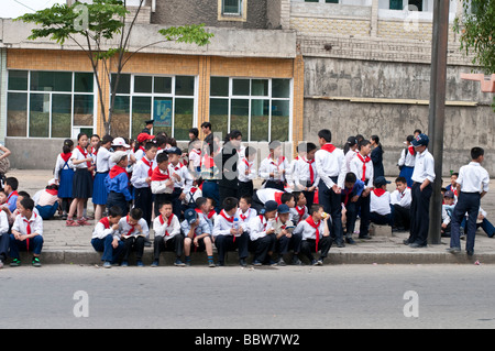 Street Shots Pyongyang Corea del Nord con un gruppo di giovani studnets in attesa di un automobile della via Foto Stock