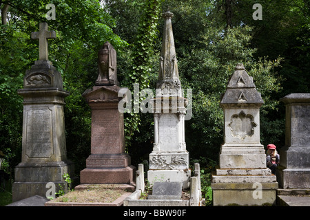 Ragazza giovane gioca intorno a Grand Victorian memorial pietre tomba nel cimitero di Nunhead durante la giornata porte aperte. Foto Stock