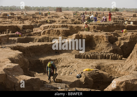 Le donne fanno mattoni per una più sostanziale alloggiamento nella scorched sterile sporco di 4 kmq Abu Shouk Refugee Camp in Al Fashir Foto Stock