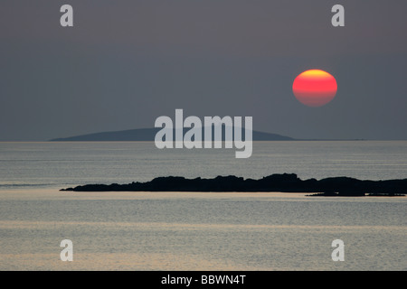 Atlantic Iona Sunset over Eilean Annraidh (primo piano) e Tiree,da Kintra bay,Isle of Mull,la Scozia occidentale,Gran Bretagna,UK. Foto Stock