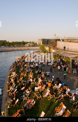 Persone catturare gli ultimi raggi del sole lungo il fiume Sprea a Berlino Foto Stock