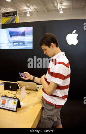 Adolescente esaminando l'iPhone al supporto Apple nel negozio Best Buy, STATI UNITI D'AMERICA Foto Stock