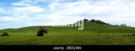 Vista panoramica del tipico paesaggio di primavera nelle Crete Senesi, Toscana, con case coloniche sulla collina e viale di cipressi Foto Stock