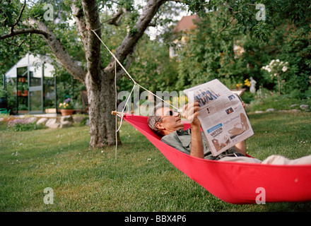 Un uomo in un amaca in Svezia. Foto Stock