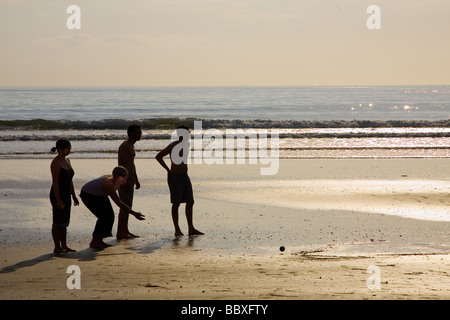 Giocando a bocce in spiaggia al tramonto Foto Stock