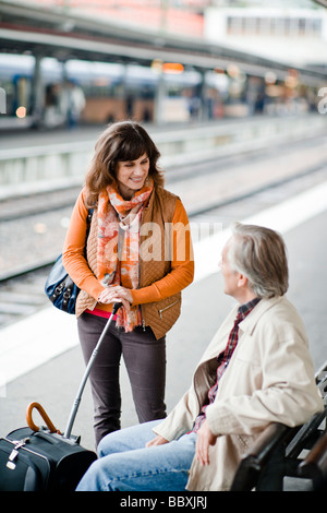 Un uomo e una donna su una piattaforma in corrispondenza di una stazione ferroviaria in Svezia. Foto Stock