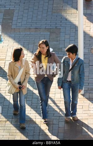 Tre amici asiatici attraversando a piedi il quartiere turistico di Circular Quay. Sydney, Australia. Foto Stock
