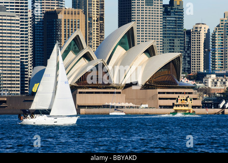 Yacht con vele bianche e altre imbarcazioni sulle acque blu della baia di Sydney, passato a vela Sydney Opera House. Foto Stock