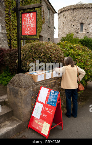 Una donna navigando scatole di libri al di fuori di una seconda mano bookshop in St Davids Pembrokeshire Wales UK Foto Stock