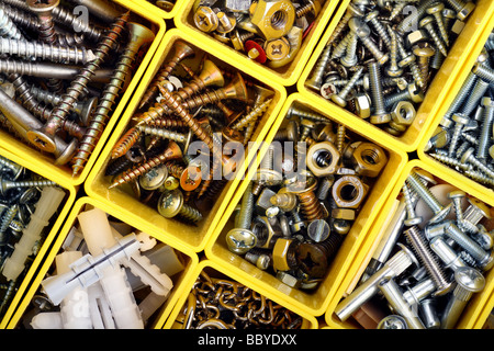 Viti, dadi, bulloni e altri falegname roba in un giallo la cassetta degli attrezzi di plastica Foto Stock