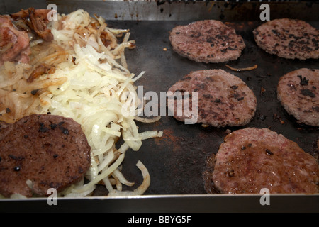 Cipolle hamburger essendo cotti su una piastra riscaldante aperta per la vendita a un evento pubblico contea di Down Irlanda del Nord Regno Unito Foto Stock