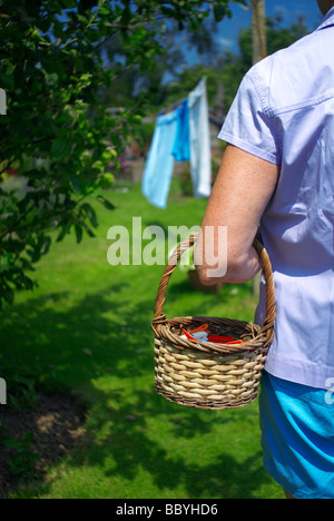 La donna nel giardino appendere fuori il lavaggio Foto Stock