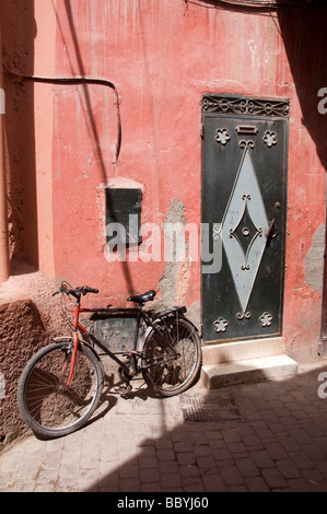 Vicolo scena di strada nella vecchia medina quartiere dello shopping di Casablanca in Marocco con particolare architettura della porta e la vecchia bicicletta Foto Stock