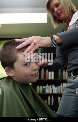 Non-così-ragazzo entusiasta di ottenere un taglio di capelli Foto Stock
