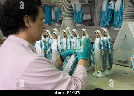 Una donna verniciato finitura le statue della Vergine Maria la principale industria nella piccola città di Coreglia Antelminelli in Garfagnana Foto Stock