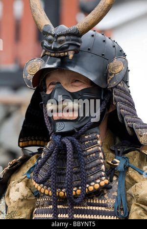 Uomo vestito in pieno il samurai armor completo con casco kabuto e mempo maschera facciale per intimidire il nemico Foto Stock