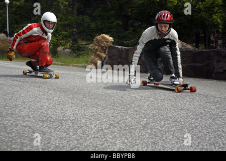 Due skateboarders protettivo di indumenti di cuoio Indumenti di cuoio gara giù per la strada Foto Stock