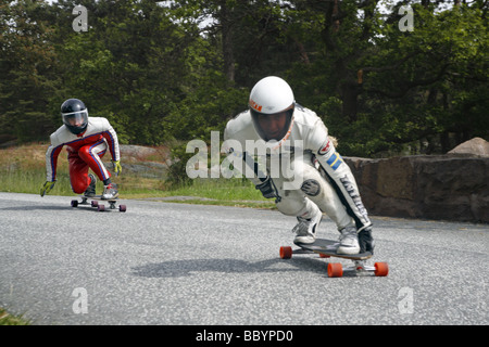 Due skateboarders protettivo di indumenti di cuoio Indumenti di cuoio gara giù per la strada Foto Stock