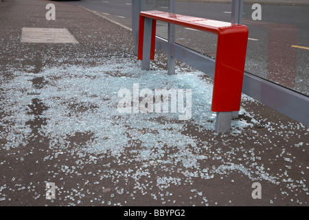 Vetro frantumato giacente a terra da un soggetto ad atti vandalici bus shelter in Irlanda del Nord Foto Stock