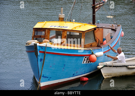 L'uomo pittura barca in porto, Mevagissey, Cornwall, England, Regno Unito Foto Stock