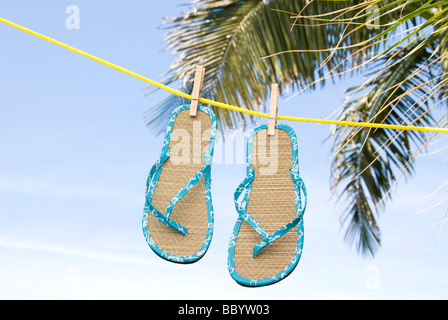 Una coppia di flip flop essiccamento in una brezza tropicale su uno stendibiancheria Foto Stock