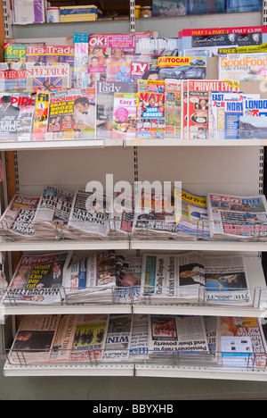 Inglese quotidiani e riviste patinate su un ripiano per la vendita in un Regno Unito giornalai shop store Foto Stock