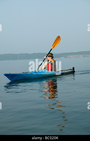 Kayaker femmina su un lago. Foto Stock