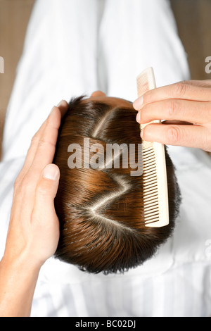 Angolo di alta vista del parrucchiere utilizzando il pettine Foto Stock