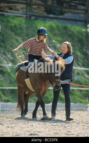 Ragazza giovane imparare a cavalcare un cavallo islandese (Equus caballus) Foto Stock