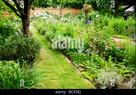 Tarda primavera aiuole di fiori in un suburban giardino inglese Foto Stock