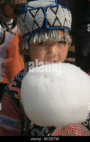 Carino Hani ragazza di minoranza di mangiare il cotone candy Yuanyang in Cina Foto Stock