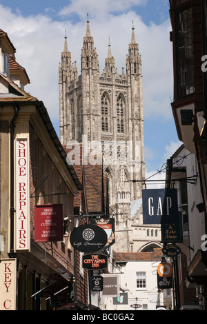 Vista della cattedrale di Canterbury chiesa torre lungo la stretta strada di negozi nel centro della citta'. Canterbury Kent England Regno Unito Gran Bretagna Foto Stock