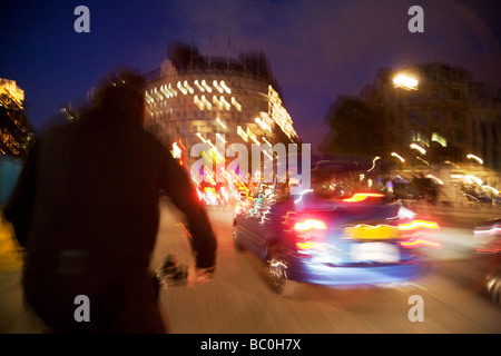 Volutamente sfocata taxi di Londra di notte visto da un risciò bicicletta, Trafalgar Square, London, Regno Unito Foto Stock