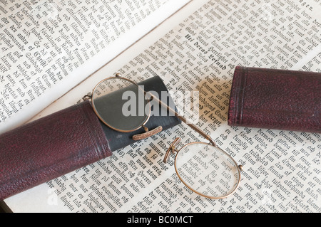 Una coppia di vecchi pince-nez occhiali con custodia sulla vecchia Bibbia svedese. Foto Stock