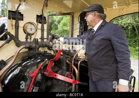 Macchinista/vigile del fuoco nella cabina del motore della locomotiva a vapore motore sul Llanfair Light Railway attrazione turistica Foto Stock