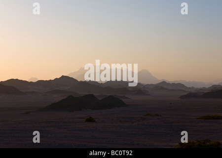 Panorama attraverso il deserto piano distante gamme della montagna nella mattina presto luce, Deserto Orientale dell Egitto, Africa Foto Stock