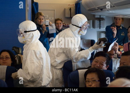 Lavoratori medici a bordo di un aereo da Amsterdam controllare i passeggeri per i segni di febbre (influenza suina) dopo lo sbarco a Shanghai Foto Stock