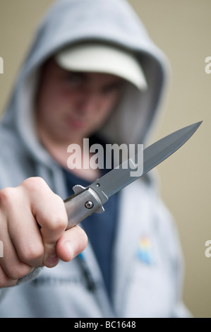 La gioventù in felpa con cappuccio brandendo sfiora il coltello Foto Stock