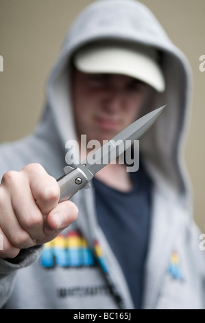 La gioventù in felpa con cappuccio brandendo sfiora il coltello Foto Stock