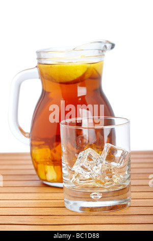 Ice Tea lanciatore e glasss vuoto con icecubes su sfondo di legno leggera profondità di campo Foto Stock