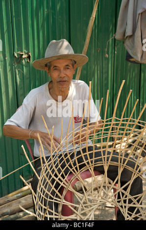 Un vecchio uomo che fa un cesto di vimini in Luang Prabang Laos Foto Stock