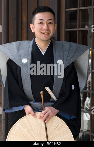 Un uomo che indossa una formale tradizionale costume samurai in posa per una foto durante la Takayama Festival di Primavera Foto Stock