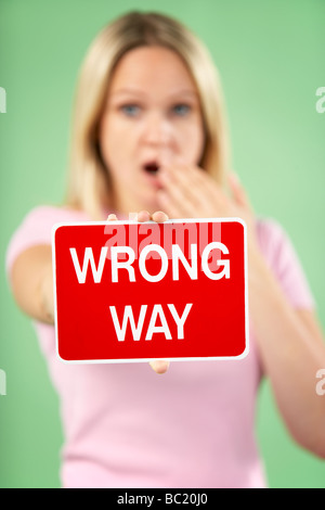 Donna che mantiene il traffico stradale segno Foto Stock