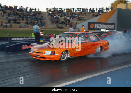 Australian sovralimentato VK Holden Commodore drag race car eseguendo un pneumatico di fumare burnout Foto Stock