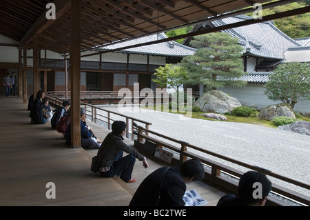 Gli ospiti seduti sulla veranda e contemplare la bianca rastrellata ghiaia di un giardino di pietra al Tempio di Nanzenji in Kyoto Foto Stock