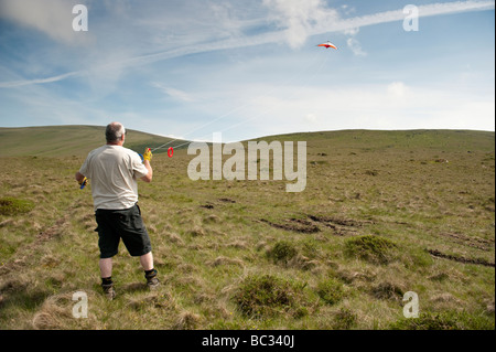 Un uomo di mezza età volare un aquilone sul Preseli Hills nord pembrokeshire nel Galles un pomeriggio estivo Foto Stock
