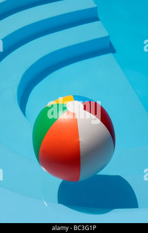 Beachball floating in ancora una piscina Foto Stock