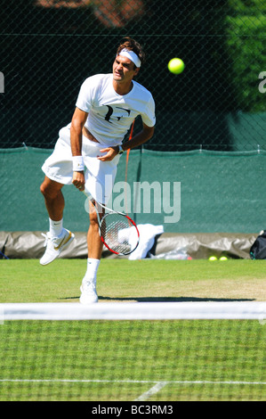 La Svizzera Roger Federer gioca con Sam Querry su una pratica in tribunale durante il 2009 campionati di Wimbledon Foto Stock