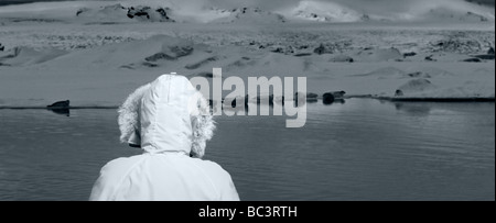 Giovane ragazza in parka guarnizioni in background, Jokulsarlon, Breidamerkurjokull Glacier, Islanda Foto Stock