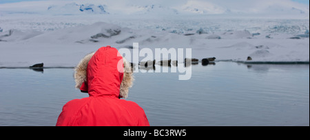 Giovane ragazza in parka guarnizioni in background, Jokulsarlon, Breidamerkurjokull Glacier, Islanda Foto Stock